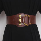 Gold-buckle belt worn over a coat